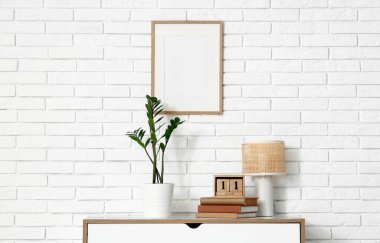 Kitaplarla dolu küp takvimi, odadaki çekmecelerin üzerinde bitki ve lamba