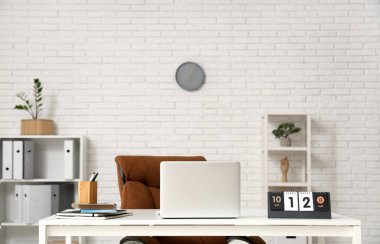 Ofiste dizüstü bilgisayarı ve takvimi olan işyeri