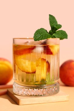 Turuncu masada bej arka planda naneli taze şeftalili limonata.