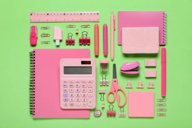 Yeşil arka planda farklı okul malzemeleri.