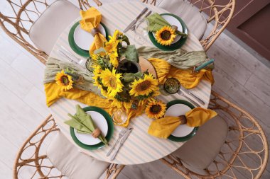 Tabaklarla servis edilen zarif masa, katlanmış peçeteler ve güzel ayçiçekleri, üst manzara.