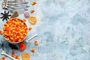 Bir kase lezzetli mısır ve mavi grunge arka planda Cadılar Bayramı süslemeleri.