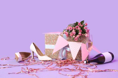 Şampanya ile yüksek topuklar, doğum günü hediyesi ve leylak arka planda dekor