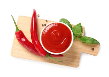 Fesleğen yapraklı, biberli ve beyaz arka planda acı biberli domates sosu.