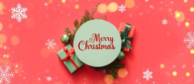 Kırmızı arka planda Noel dekoru olan yeşil yuvarlak boş kart