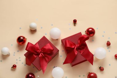 Noel baloları hediye kutuları ve turuncu arka planda konfeti.