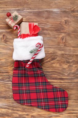 Noel çorabı hediye kutuları ve tahta arka planda şeker kamışları.