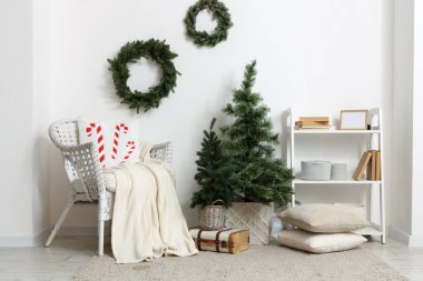 Noel ağaçları ve ökse otu çelenkleriyle modern oturma odasının şık bir iç mekanı.