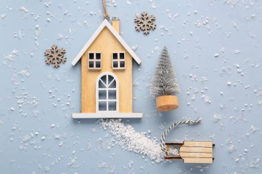 Mavi arka planda ahşap ev ve dekorlu Noel kompozisyonu