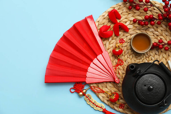 Чайник с чашкой и китайские символы на синем фоне. Новогодний праздник