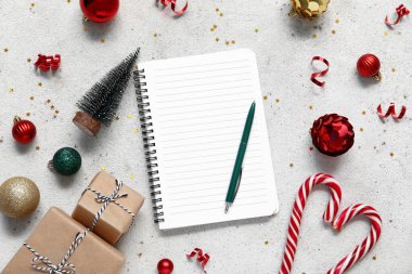 Yılbaşı süslemeleri ve grunge beyaz arka planda hediye kutuları içeren defteri aç