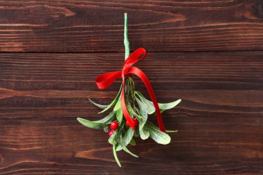 Ökseotu dalları ahşap arka planda kırmızı yay ile