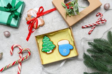 Gri arkaplanda tatlı zencefilli kurabiye, baston şeker ve köknar dalları olan hediye kutusu. Noel kutlaması