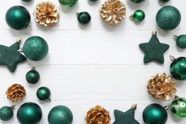 Noel toplarından yapılmış çerçeve ve beyaz ahşap arka planda boyanmış koniler.