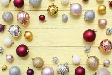 Bej ahşap arka planda farklı Noel toplarından yapılmış çerçeve