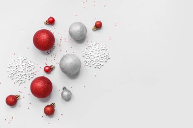 Beyaz arka planda Noel topları ve konfetileri olan güzel bir kompozisyon