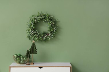 İçinde Noel ağacı olan çekmeceler, odada bir kase top ve ökseotu çelengi.