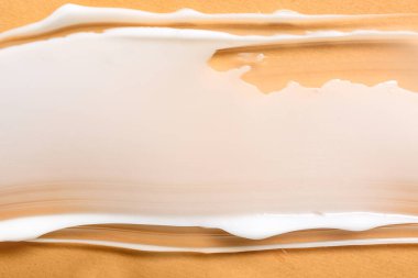 Turuncu arka planda kozmetik krem örneği