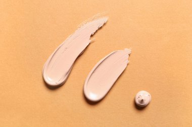 Turuncu arka planda makyaj malzemeleri.