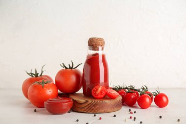 Beyaz grunge arka planda lezzetli ketçaplı kase ve şişe.