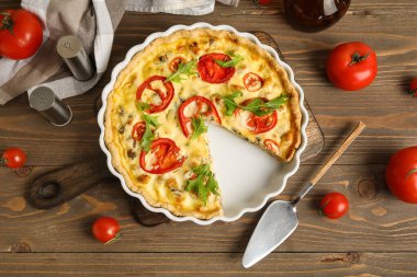 Ahşap arka planda roka yapraklı lezzetli domates tartı.