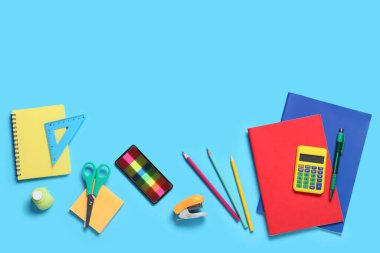 Mavi arkaplanda farklı okul kırtasiyesine sahip kompozisyon