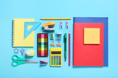 Mavi arkaplanda farklı okul kırtasiyesine sahip kompozisyon