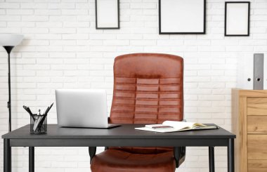 Dizüstü bilgisayarı ve koltuğu olan bir iş yeri