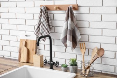 Mutfaktaki beyaz tuğla duvara asılı temiz peçeteler, yakın plan.