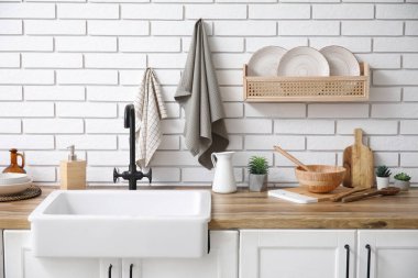 Mutfakta lavabo, mutfak gereçleri ve temiz peçeteler var.