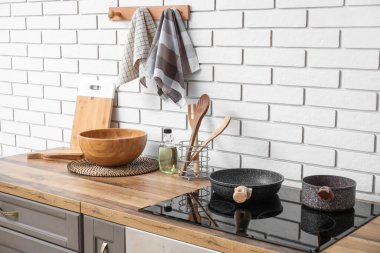 Elektrikli ocağı olan tezgahlar ve mutfakta beyaz tuğlalı duvara temiz peçeteler.