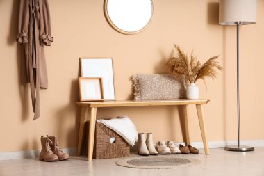 Koridorun içinde, yerde lamba ve bej duvarın yanında bank var. Yakın plan.