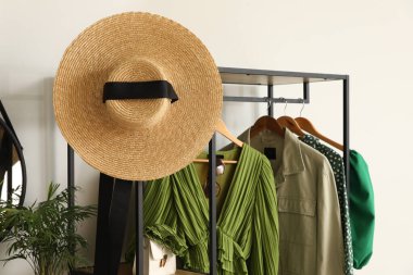 Koridordaki beyaz duvarın yanında giysi ve aksesuarlarla dizilin.