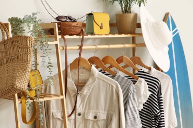 Koridordaki beyaz duvarın yanında giysilerle dizilin, yakın plan.