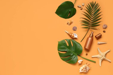 Turuncu arka planda güneş kremi, deniz kabuğu ve tropikal yapraklı yaz kompozisyonu