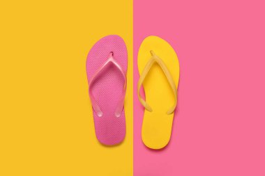 Renkli arka planda şık parmak arası terlikleri olan kompozisyon