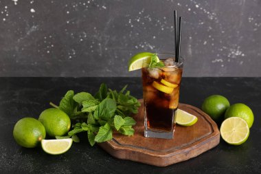 Siyah arka planda naneli ve limonlu soğuk Küba Libre kokteyli.