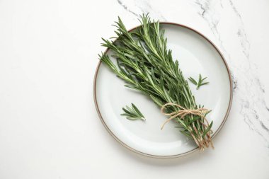 Mermer arka planda bir demet taze biberiyeli tabak.