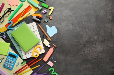 Not defterleri, gözlükler ve siyah grunge arka planı ile ilgili farklı okul malzemeleri.