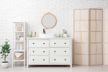 Ayna, lavabo ve tuvalet malzemelerinin olduğu hafif banyonun içi.