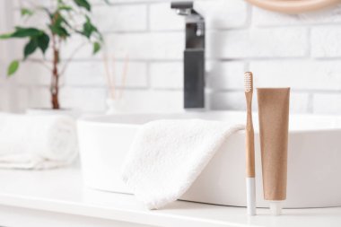 Diş fırçası ve diş macunu lavabonun yanında, yakın plan.