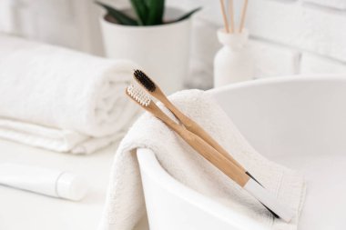 Banyoda diş fırçası, diş macunu ve havluyla lavabo, yakın plan.