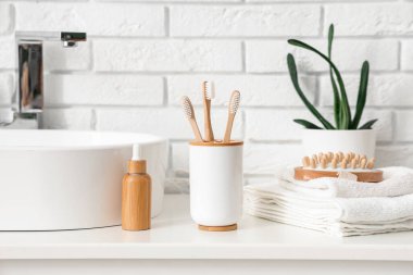 Bardakta diş fırçası ve tuvalet malzemeleri banyoda, yakın plan.