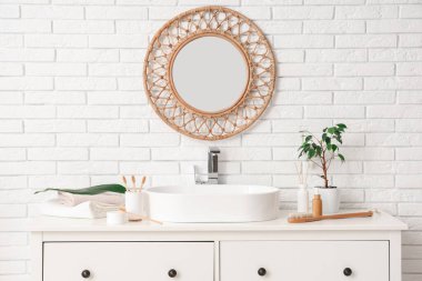 Lavabo, diş fırçası ve çekmecelerde tuvalet malzemesi olan hafif bir banyo.