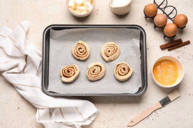 Beyaz grunge arka planda çiğ tarçınlı çörekler.