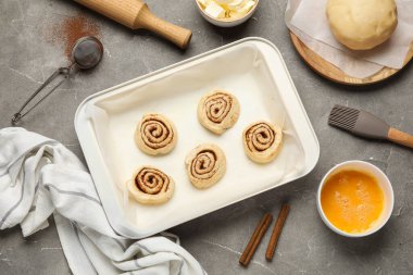 Gri grunge arka planda çiğ tarçınlı çörek tepsisi