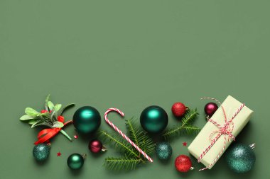 Yeşil arka planda hediye kutusu ve farklı Noel süslemeleri olan güzel bir kompozisyon