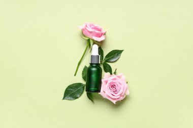 Yeşil zemin üzerinde gül yağı olan kompozisyon