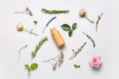 Beyaz arka planda gerekli yağ, çiçek ve yeşil yapraklarla kompozisyon