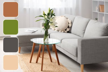 Kahve masasında gri kanepe, yastık ve nilüfer çiçeği vazosu olan şık bir oturma odası.